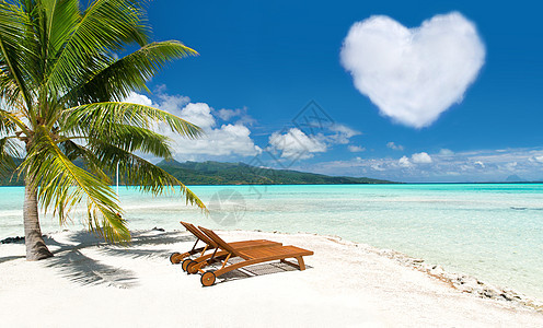 浪漫的度假热带海滩与棕榈树,两个阳光床心形云法属波利尼西亚海滩两个太阳床心形云图片