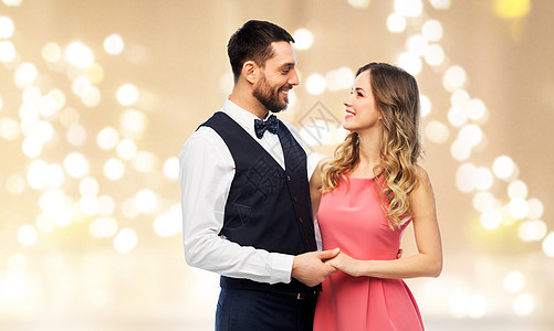 人们的幸福的夫妇穿着派服装节日的灯光背景穿着派衣服的幸福夫妇图片