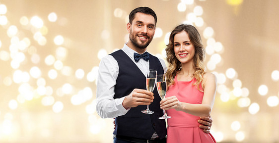 庆祝人们的幸福的夫妇与香槟杯节日的灯光背景下品尝幸福的夫妇戴着香槟酒杯祝酒图片
