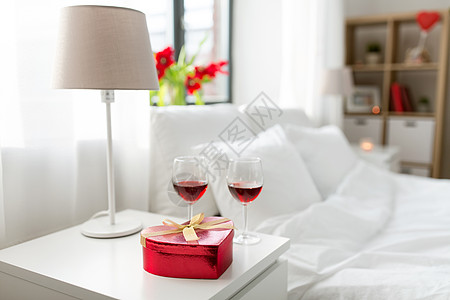 情人节,爱浪漫的心形礼品盒两杯红酒卧室床头柜家里家里卧室里礼物两杯酒背景图片