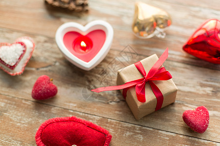 诞节,情人节假日礼品盒与心形装饰蜡烛燃烧木制背景诞礼物,心形装饰品,蜡烛图片