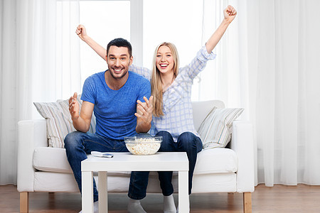人,家庭休闲的幸福的微笑夫妇爆米花家里看电视幸福的夫妇家里看电视吃爆米花图片