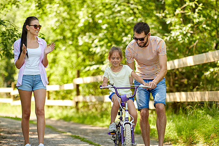 家庭,父母,休闲人的快乐的母亲,父亲小女儿学骑自行车夏季公园专利的孩子公园学骑自行车图片