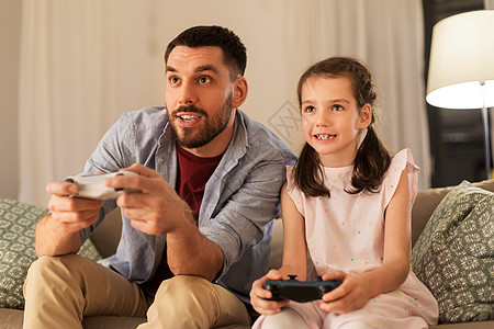 家庭,游戏娱乐活动快乐的父亲小女儿家里玩电子游戏父亲女儿家玩电子游戏图片