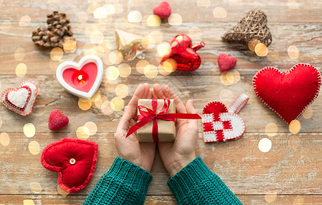 诞节,情人节假日女手礼品盒与心形装饰蜡烛燃烧木制背景手诞节情人节礼物图片
