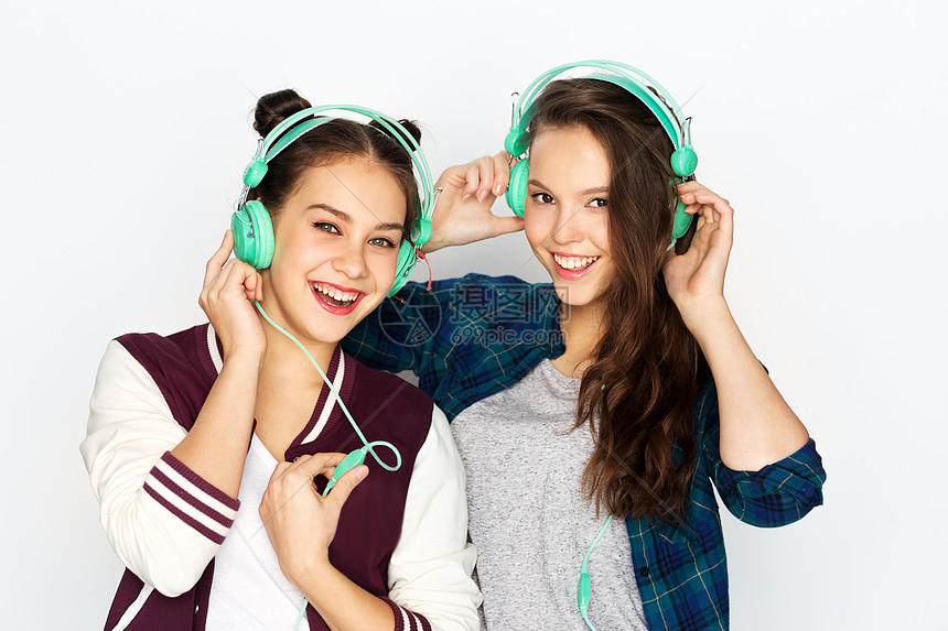 人,休闲技术的微笑的十几岁女孩耳机听音乐的白色背景十几岁的女孩戴着耳机听音乐图片