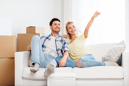 移动,人,维修房地产幸福的夫妇与大纸板箱沙发上的新家新家纸板箱的幸福夫妇图片