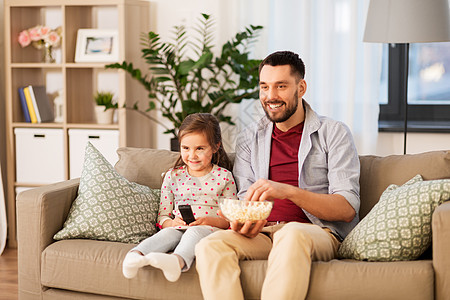 家庭,父亲人的快乐的父亲女儿家里看电视爆米花快乐的父亲女儿家看电视图片