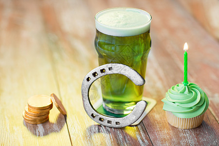 帕特里克日,假日庆祝璃绿色啤酒,纸杯蛋糕与蜡烛,马蹄铁金币木桌上杯啤酒,纸杯蛋糕,马蹄铁金币图片