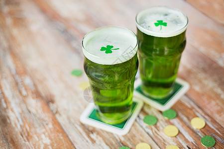 帕特里克日,假日庆祝杯绿色啤酒与三叶草金币木制桌子上杯带三叶草金币的绿色啤酒图片