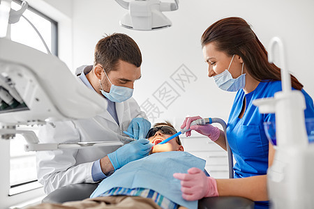 医学,牙科医疗牙科医生助理与牙科钻唾液喷射器治疗儿童患者牙齿牙科诊所牙医牙科诊所治疗儿童牙齿图片