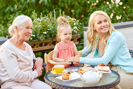 家庭,世代人的快乐的母亲,女儿祖母咖啡馆餐厅露台咖啡馆的母亲女儿祖母图片