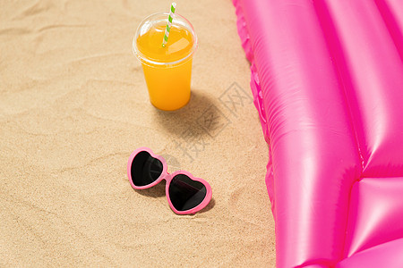 粉红色沙滩假期暑假的粉红色太阳镜,橙汁海滩沙滩上的游泳床垫太阳镜,果汁海滩沙滩床垫背景