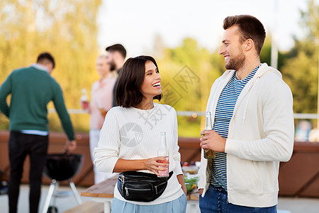 休闲,庆祝人们的幸福的夫妇与饮料瓶屋顶聚会屋顶派上喝饮料的幸福夫妇图片