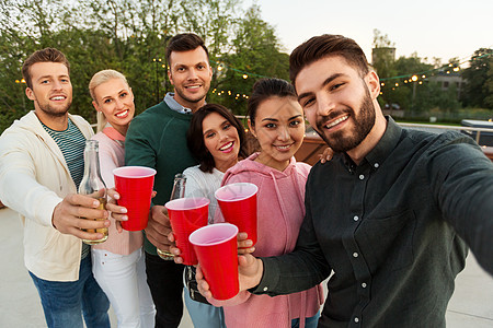 休闲人们的快乐的朋友与饮料自拍屋顶聚会夏天饮料的朋友屋顶派上自拍图片