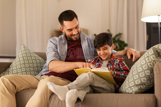 家庭,童,父爱,休闲人的快乐微笑的父亲小儿子家里沙发上看书快乐的父子家看书沙发图片