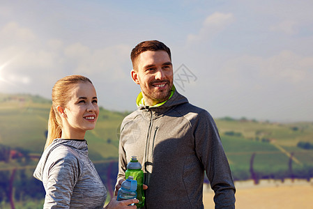 健身,运动人的微笑夫妇与瓶装水乡村景观背景户外运动后,带着瓶子的水图片