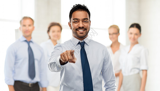 商业,招聘人的微笑的印度商人指着你穿着衬衫,队背景上打着领带商人指着你的商业队图片