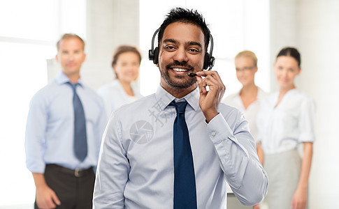 商业,客户服务人的微笑的印度商人帮助热线运营商耳机同事的背景印度商人耳机帮助热线接线员图片