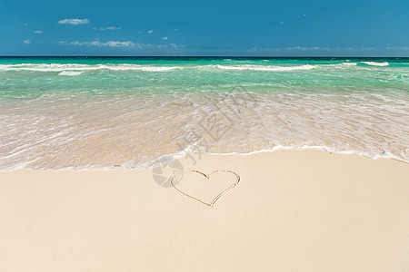 浪漫的度假情人节热带海滩与蓝色的水心形画沙子上热带海滩,心沙滩上图片