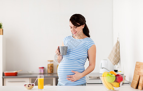 怀孕,人们健康的饮食观念快乐的孕妇喝杯茶食物,家里的厨房吃早餐快乐的孕妇家里的厨房里着杯子图片