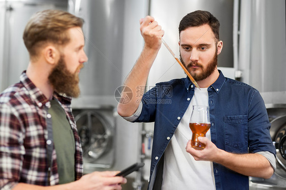酒精生产,制造,商业人的男啤酒制造商与吸管剪贴板测试工艺啤酒啤酒厂啤酒厂用吸管测试工艺啤酒的男人图片