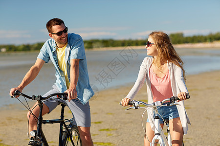 人们,休闲生活方式的快乐的轻夫妇骑自行车海滩上快乐的轻夫妇海边骑自行车图片