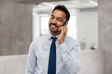 商业,沟通人的微笑的印度商人办公室背景下打电话给智能手机印度商人办公室打电话给智能手机图片