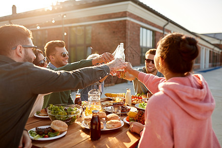 休闲人们的快乐的朋友屋顶聚会野餐夏天品尝饮料快乐的朋友屋顶聚会上品尝饮料图片
