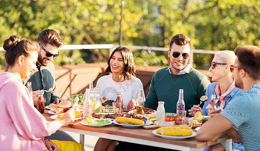 休闲人们的快乐的朋友夏天的屋顶聚会上吃喝快乐的朋友屋顶聚会上吃喝图片