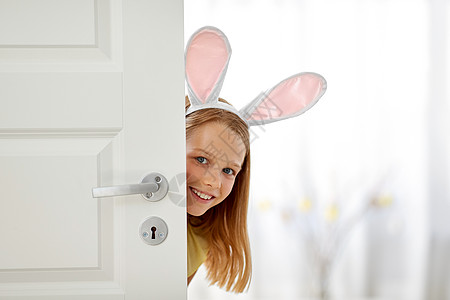 复活节,假期人们的快乐的女孩戴着兔子的耳朵家里偷看外的门快乐的女孩,复活节兔子的耳朵偷看门外图片