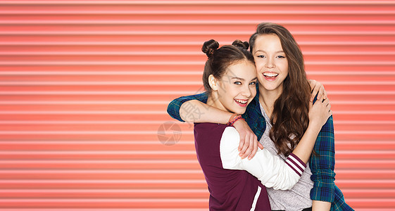 人,青少友谊的快乐的微笑,漂亮的十几岁的女孩朋友拥抱条纹生活珊瑚背景快乐的十几岁的女孩朋友拥抱图片