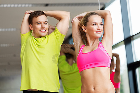运动,健身,健康的生活方式人们的微笑的男人女人健身房伸展微笑的男人女人健身房锻炼图片
