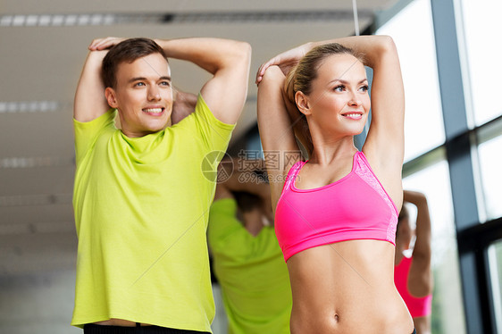 运动,健身,健康的生活方式人们的微笑的男人女人健身房伸展微笑的男人女人健身房锻炼图片
