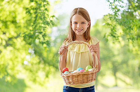 复活节,假日人们的快乐的女孩与彩色鸡蛋柳条篮子绿色的自然背景快乐的女孩带着彩蛋柳条篮子里图片