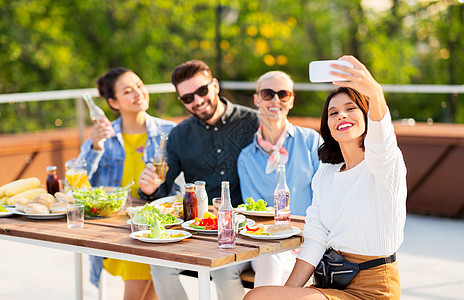 休闲人们的快乐的朋友与非酒精饮料屋顶上举行晚餐聚会,智能手机自拍快乐的朋友屋顶派上自拍图片
