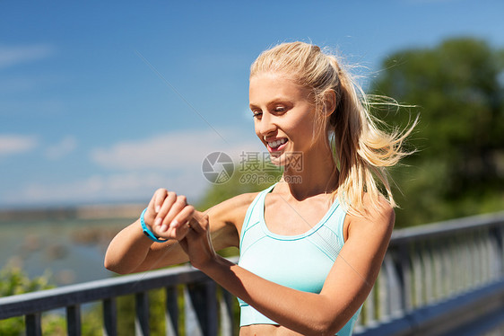 运动,人,技术健康的生活方式微笑的轻妇女与健身追踪器锻炼户外快乐的女人与健身追踪器锻炼图片