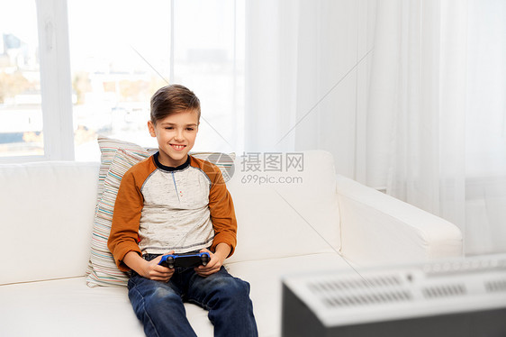 游戏,技术人的微笑男孩与游戏垫电视上玩电子游戏家快乐的男孩家里玩电子游戏图片