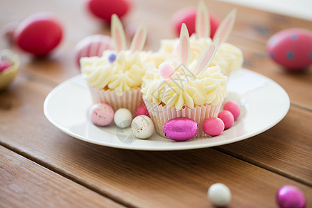 复活节,食物假日木桌上彩色鸡蛋糖果的磨砂纸杯蛋糕桌上复活节鸡蛋糖果的纸杯蛋糕图片
