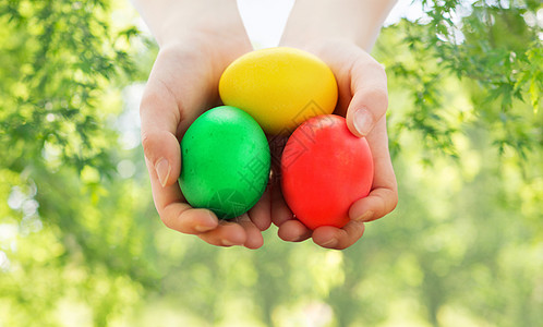 复活节,假日人们的特写女孩着碗彩色鸡蛋绿色的自然背景用碗彩色复活节彩蛋把女孩关来图片