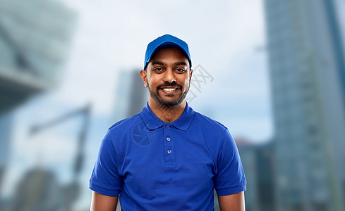 邮件服务,工作人的快乐的印度送货人穿着蓝色制服东京城市摩天大楼的背景穿着蓝色制服的快乐印度送货员图片