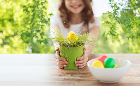 复活节,假期孩子的女孩与玩具鸡花盆与草彩色鸡蛋绿色的自然背景花盆里用玩具鸡把女孩关来图片