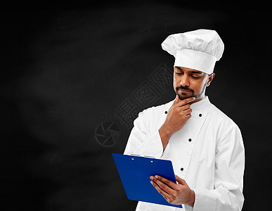烹饪,职业人的男印度厨师卡通阅读菜单上的剪贴板黑色黑板背景厨师黑板上阅读黑板上的菜单图片