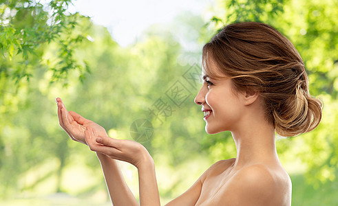 美丽人的微笑的轻女人,赤裸的肩膀,着些想象的绿色自然背景微笑的轻女人着想象中的东西图片