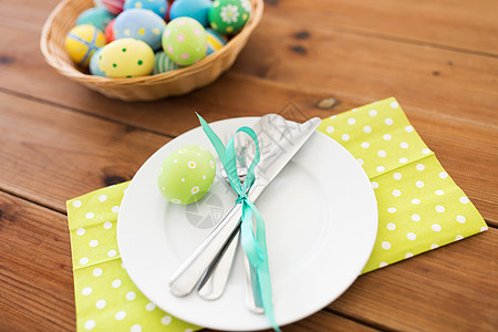 复活节,假日餐桌盘子与餐具彩色鸡蛋木制桌子上餐桌复活节彩蛋图片