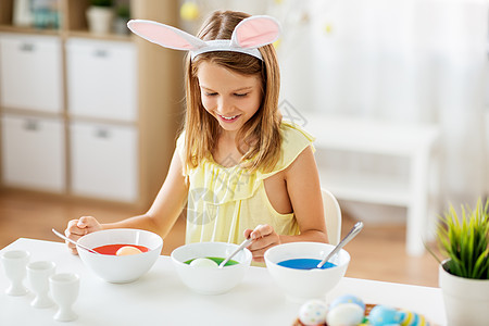 复活节,假日人们的快乐的女孩戴兔子耳朵,头巾着色鸡蛋家里液体染料女孩家里用液体染料给复活节彩蛋着色图片