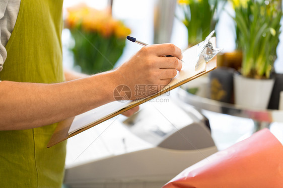 人,零售业务花卉花店男子与剪贴板写作笔记订单花卉商店花店剪贴板的花店老板图片