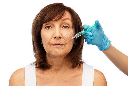 美容,整形手术美容老年女子外科医生手与注射器白色背景老年女子外科医生用注射器的手图片