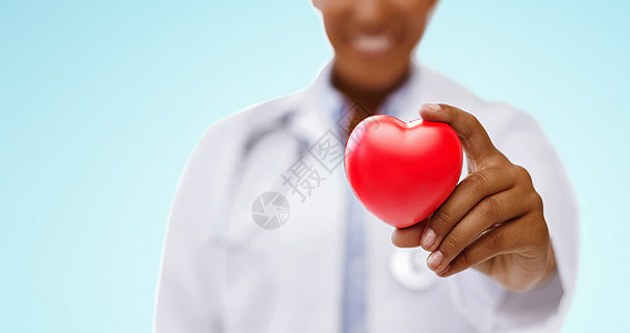 健康,医学慈善特写非裔美国女医生手握红心蓝色背景非裔美国医生手握红心图片