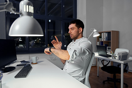 商业,技术人工智能商人用手势与智能手表夜间办公室商人夜间办公室用智能手表图片